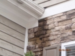 improper-roof-flashing-allows-water-run-down-front-of-manufactured-stone-veneer-wall